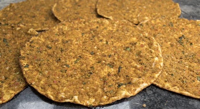 Lahmacun resting on the stone counter